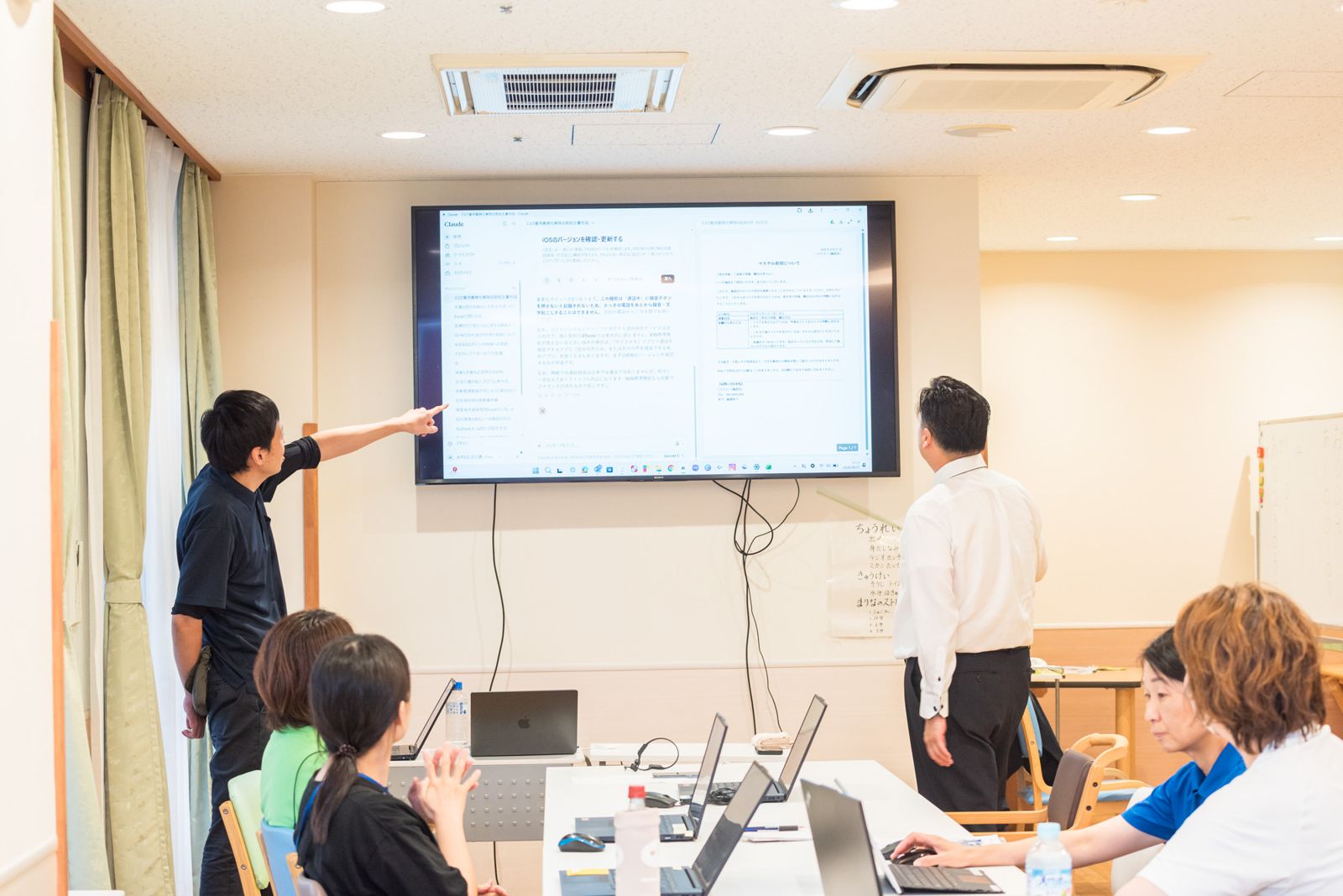 参加者が画面を指さしながら、AIでつくった文章を発表している